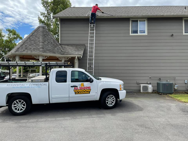 man cleaning roof gutter